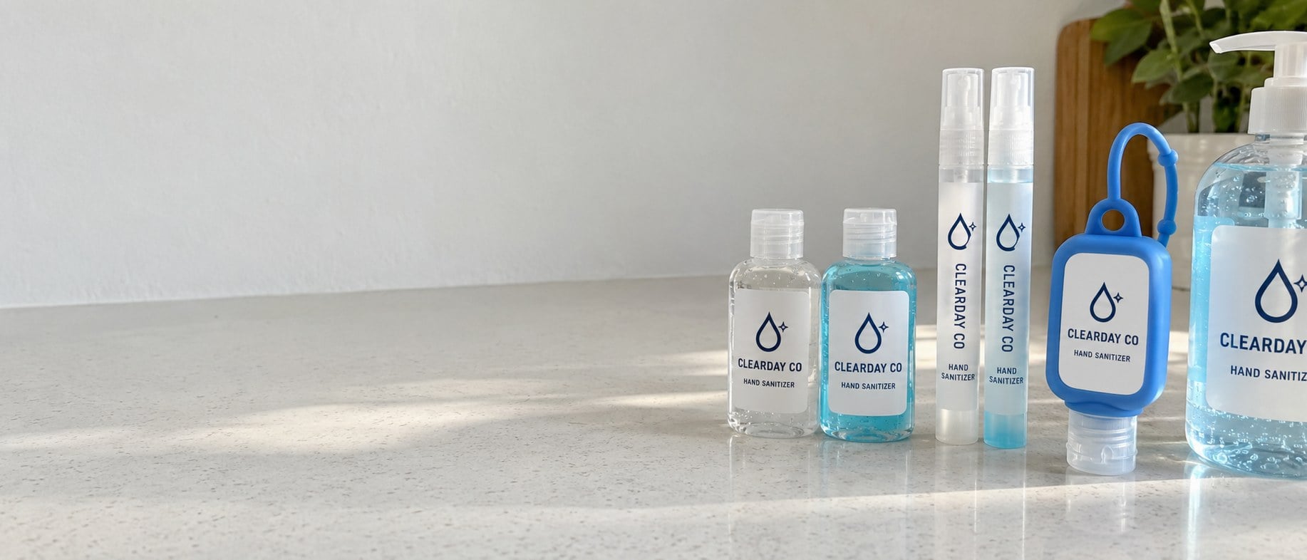Custom branded hand sanitizer bottles lined up on a white counter